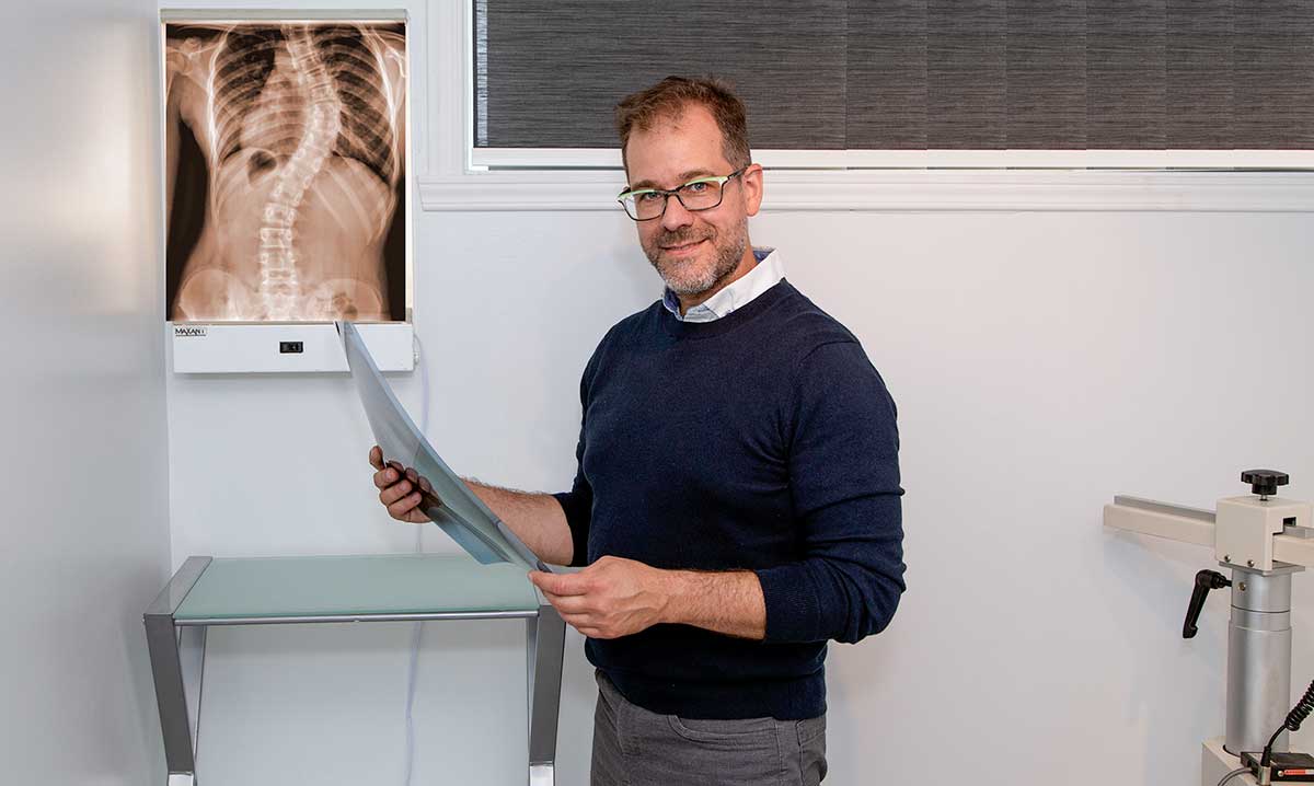 Andre Ganon chiropraticien regarde une radiographie